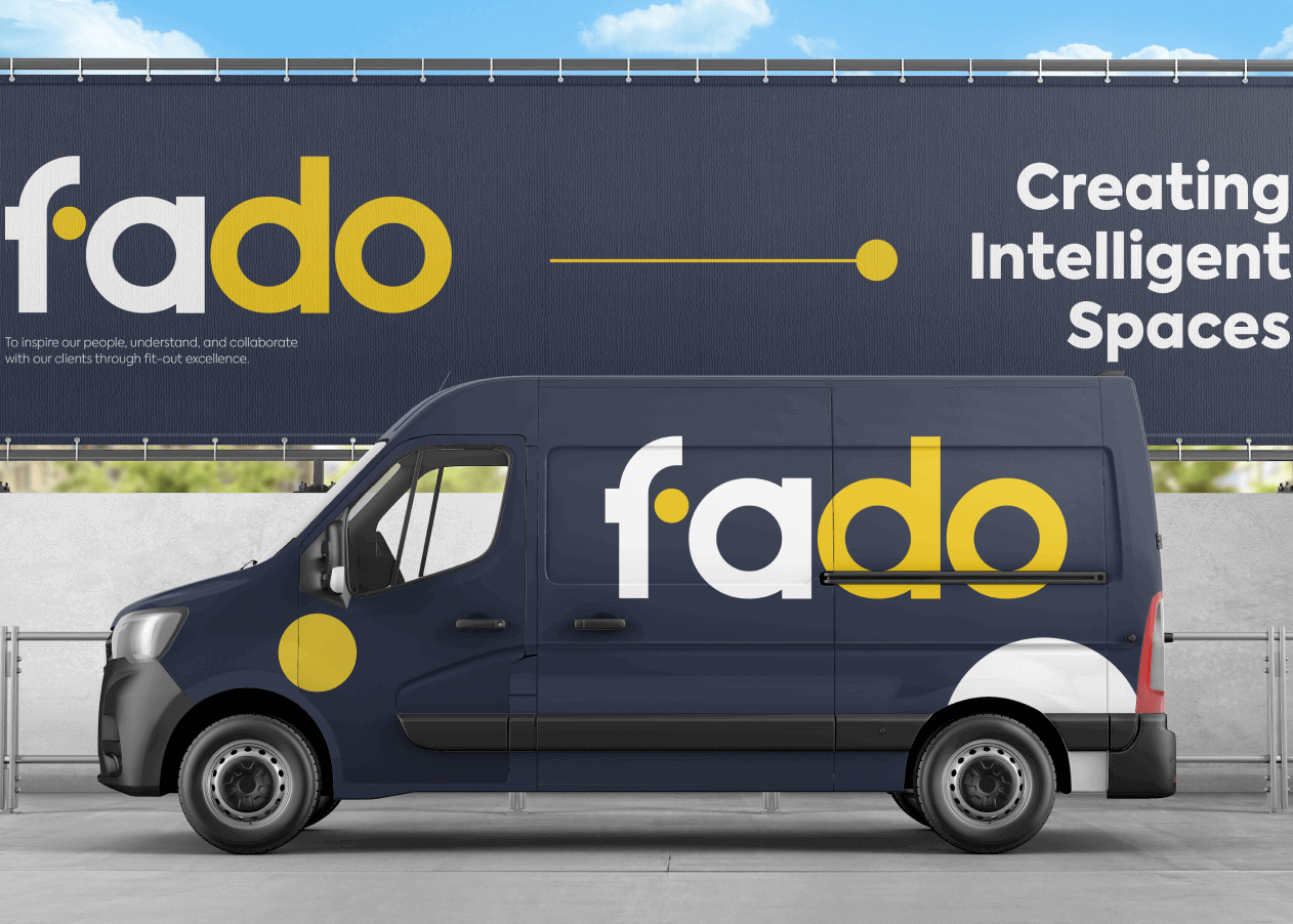 The fado van is parked in front of a billboard.